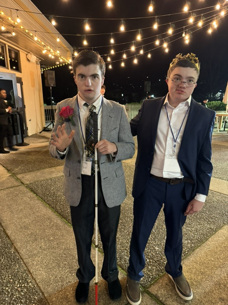 two young men with CHARGE syndrome are dressed in suits 