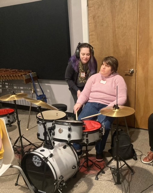 Young lady with CHARGE plays a drum set