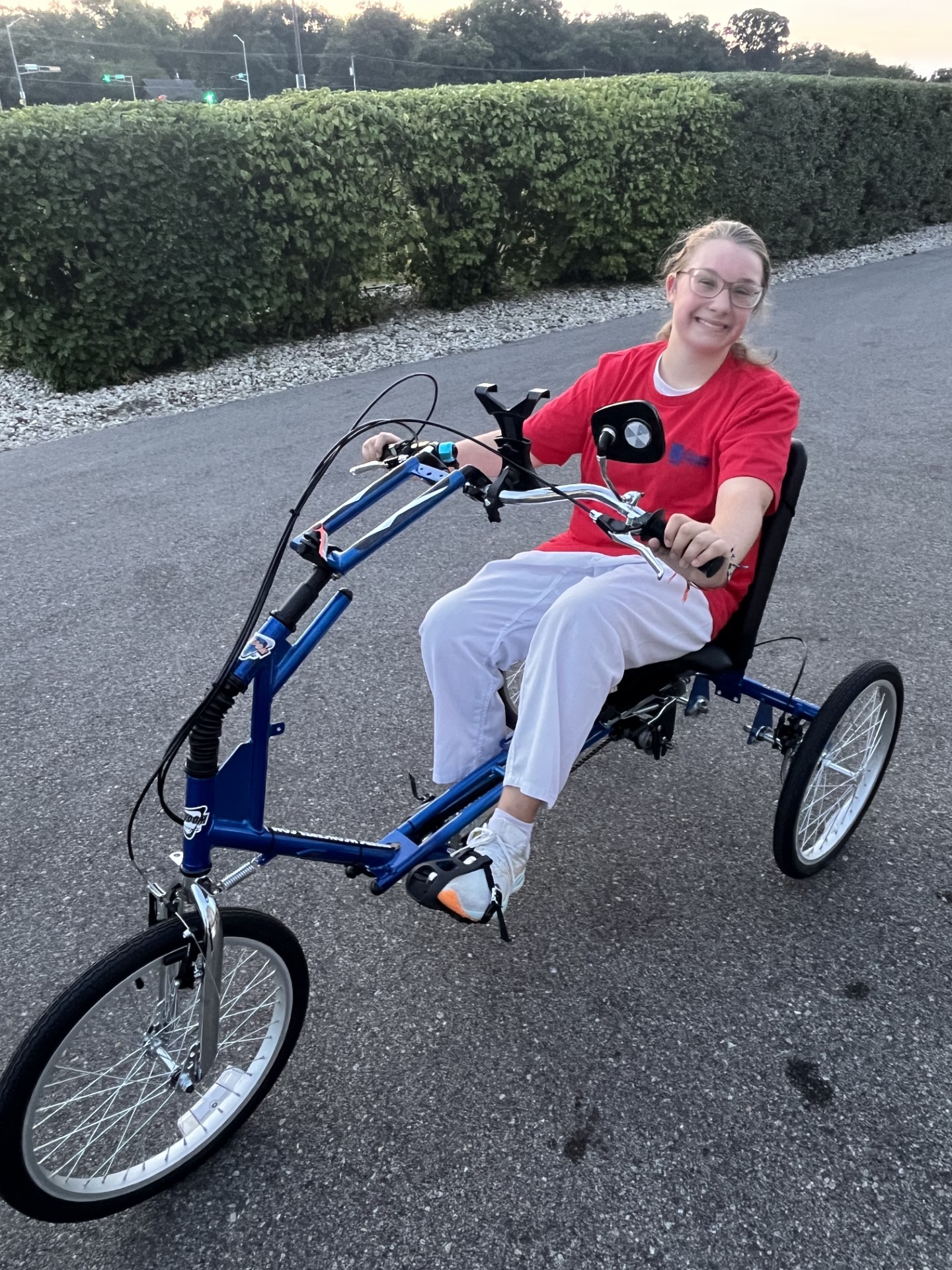 Teenage girl rides a 3-wheel adaptive bike