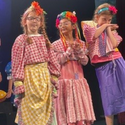 Young actors in costume on a stage. 