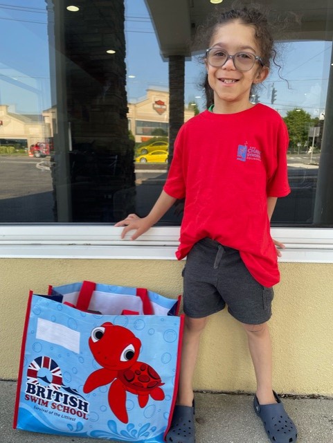 Young boy poses outside the pool building. 