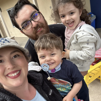 Toddler boy with CHARGE poses with mom, dad, and sister